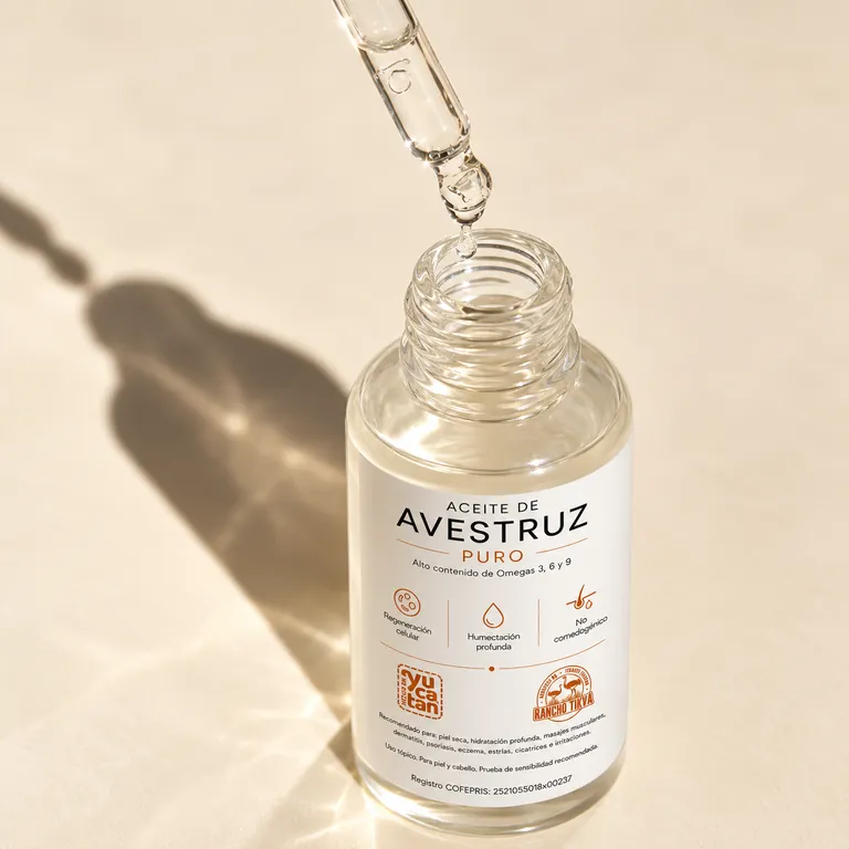 Gotero con aceite de avestruz transparente sobre el frasco